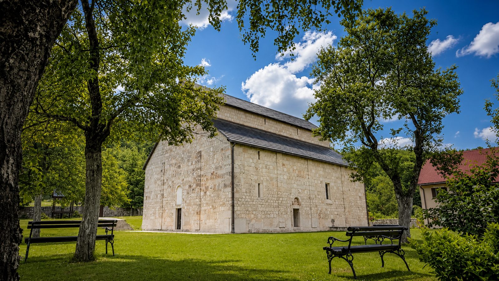 Pivski manastir od kamena okružen zelenilom i planinskim pejzažom