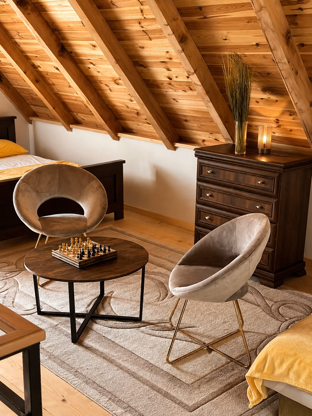 Cozy loft seating area with armchairs, chess table and exposed wooden beams